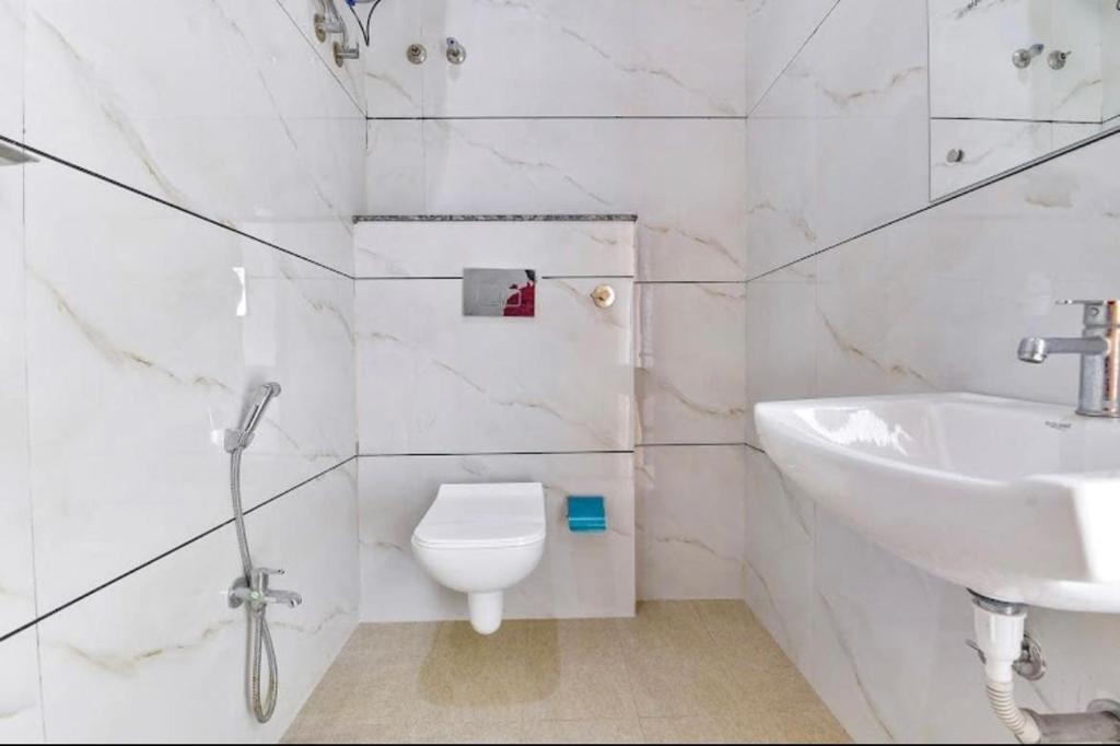 a white bathroom with a sink and a toilet at Super Collection O Hotel Roxas in Jaipur
