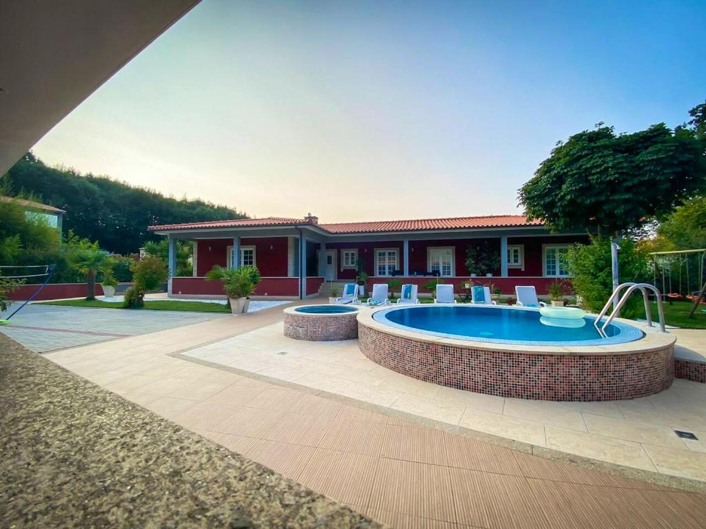 una casa con piscina y un edificio en 4 bedrooms villa with private pool jacuzzi and terrace at Rebordoes Souto, en Rebordões
