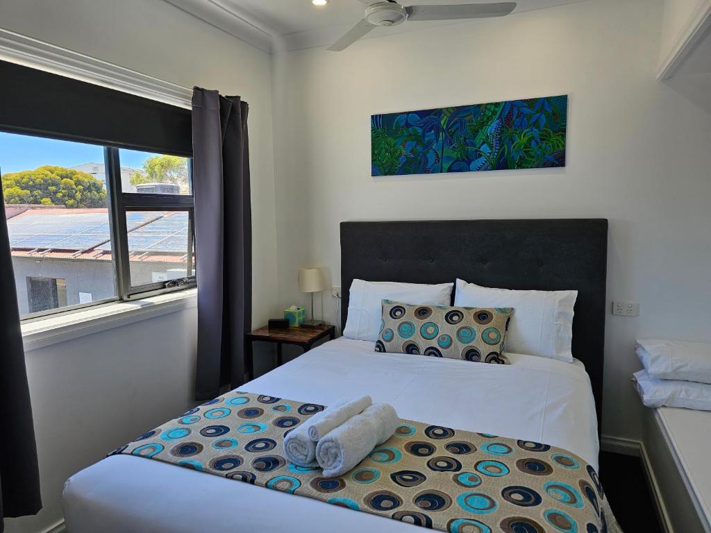 a bedroom with a bed with a large window at Aart Apartments in Port Lincoln