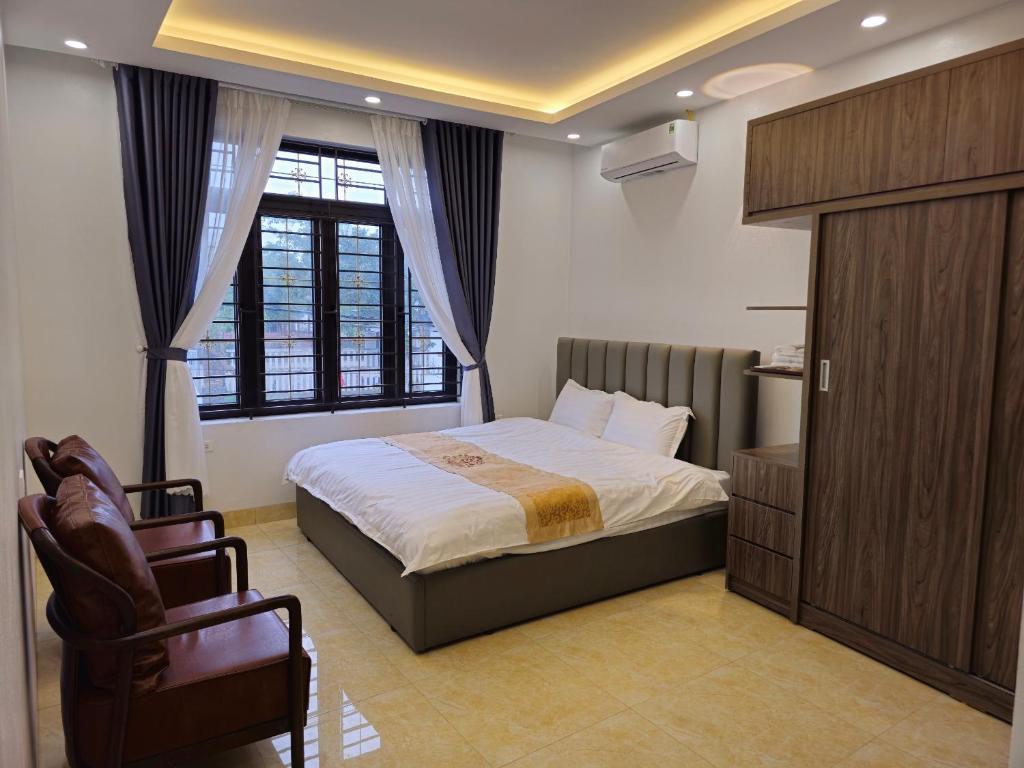 a bedroom with a bed and a chair and a window at 4L HOTEL KIM BÔI in Làng Trang