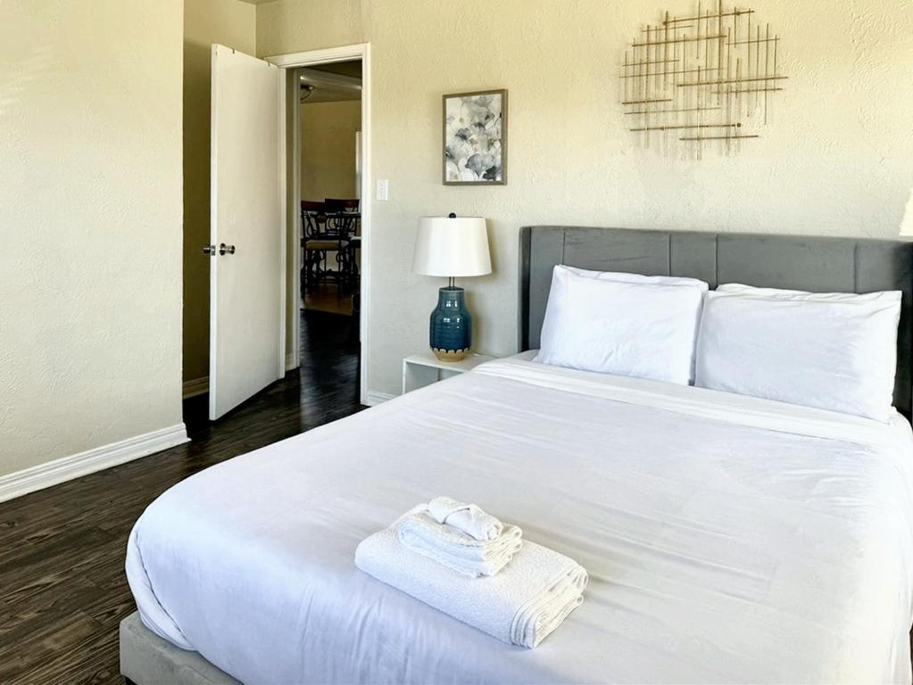 Un dormitorio con una cama blanca con toallas. en Inviting 2br House-5min To Zoo-remington Casino, en Oklahoma City