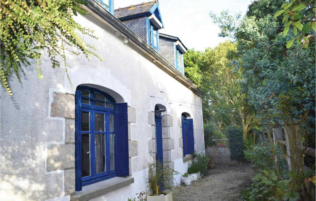 un edificio con puertas azules en un lateral en Cozy Home In Plourivo With Kitchen, en Lanleff