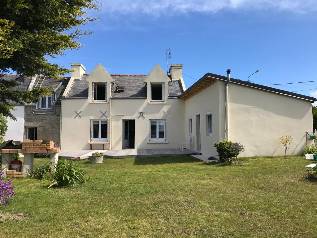 une grande maison blanche avec une cour dans l'établissement Maison bretonne traditionnelle en bord de Mer, à Plouguerneau