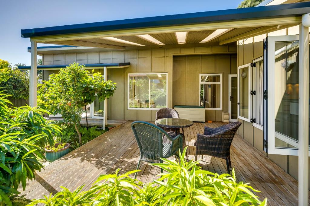 a deck with chairs and a table on a house at Garden Retreat - Napier Holiday Home in Napier
