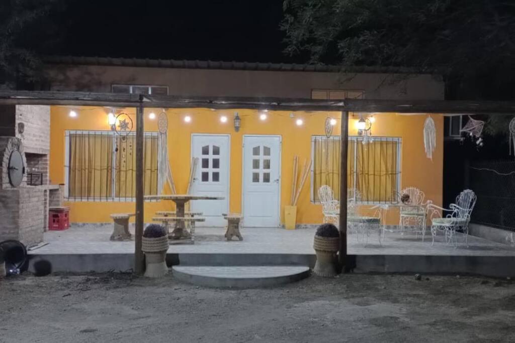 Casa amarilla con mesa y patio en Hospedaje La Ushuta Negra in 