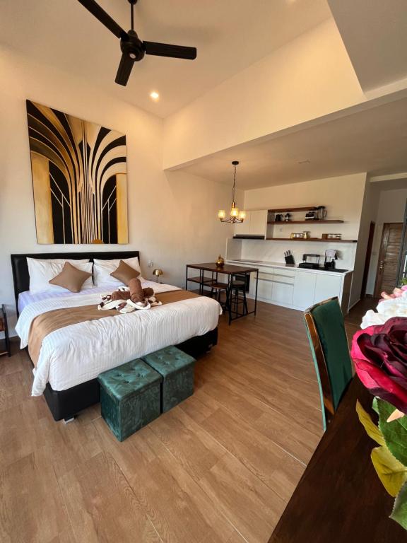 a bedroom with a large bed and a kitchen at Luxury Apartment at Lipah Beach in Ambat