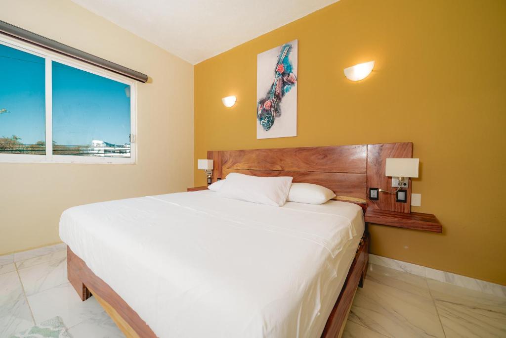 1 dormitorio con cama grande y ventana grande en Guitarra Inn, en Puerto Escondido