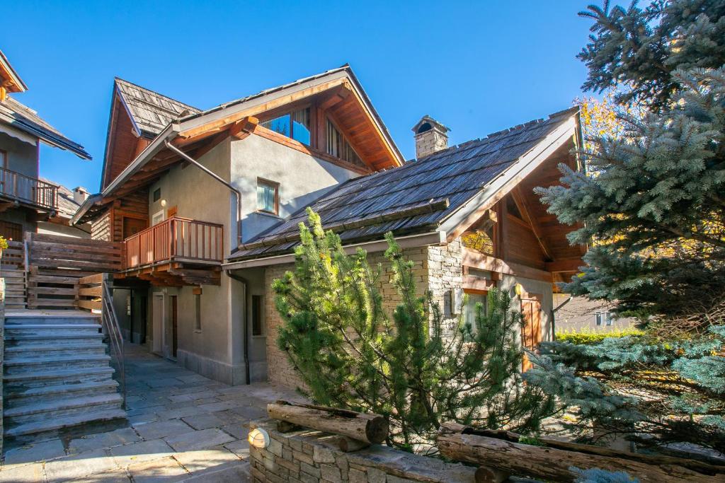 a house with a gambrel roof and a stairway at Fiori di Miele - Happy Rentals in Bardonecchia