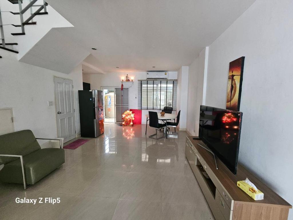 a living room with a tv and a couch and a table at 98/61 home in Ban Khlong Prawet