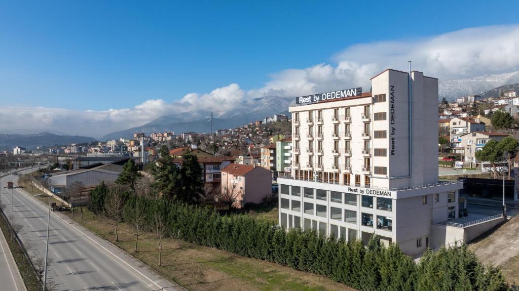 un edificio blanco alto al lado de una calle en Rest by Dedeman Karabük, en Karabük