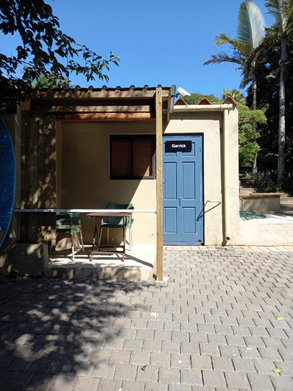 a building with a table and a blue door at Ocean Walk Garrick in Zinkwazi Beach