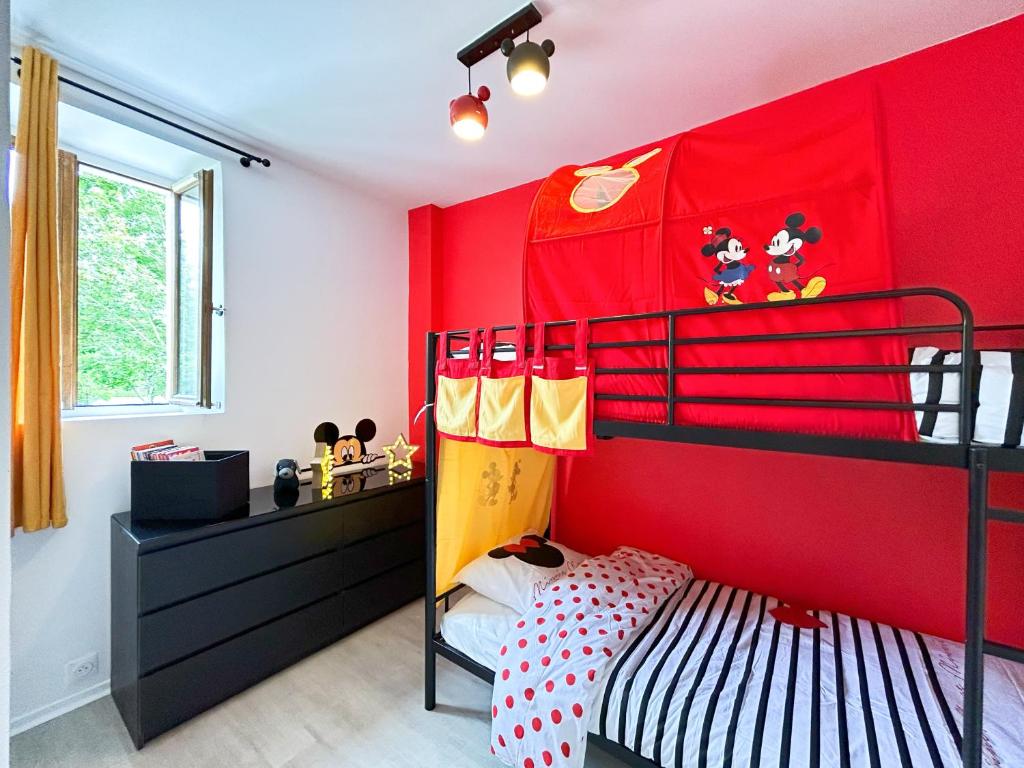 - une chambre rouge avec des lits superposés et des décorations sur souris mickey dans l'établissement MikiHouse - Disneyland, à Bailly-Romainvilliers