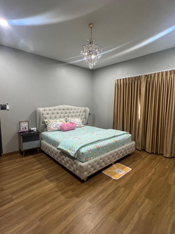 a bedroom with a bed and a chandelier at Pani House ( Hatyai 3 ) in Hat Yai