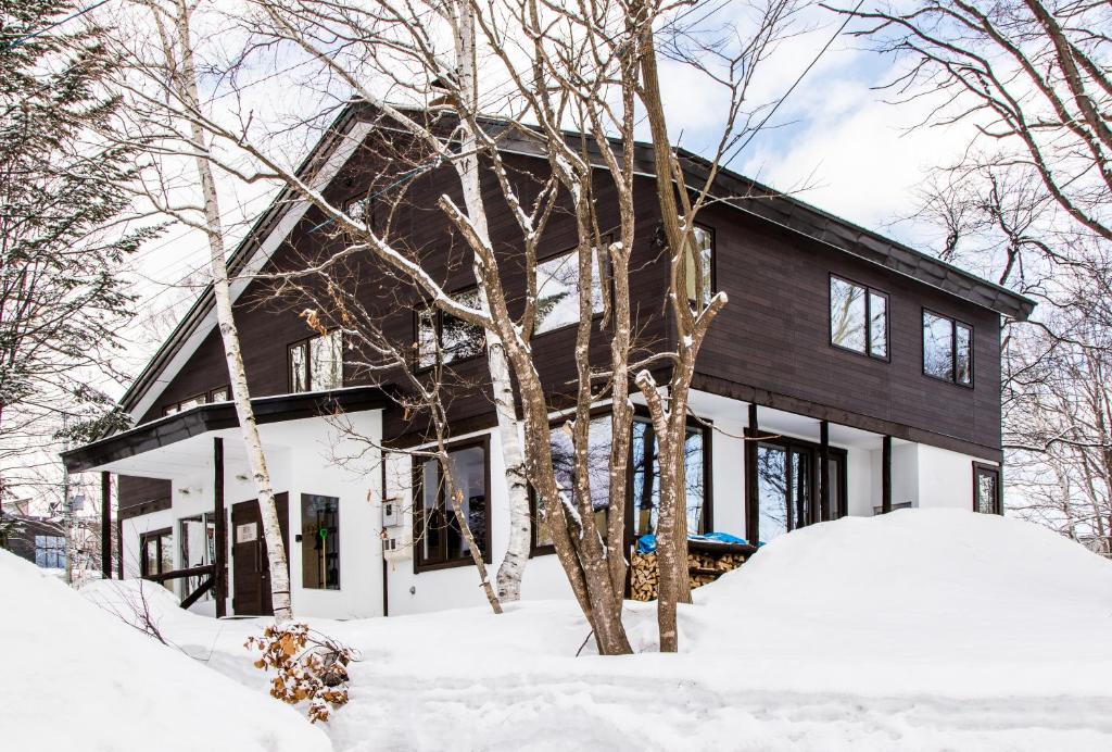 a house in the winter with snow in front of it at Gensei in Niseko