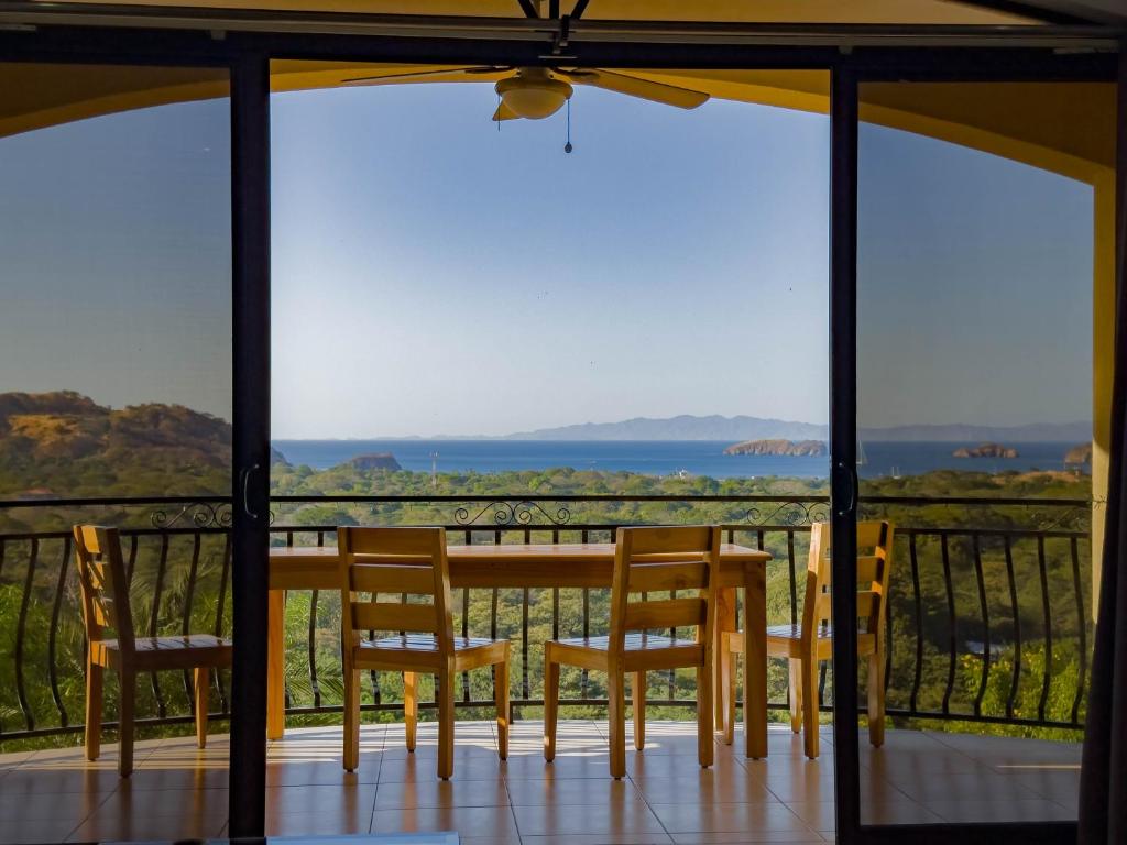 una mesa y sillas en un balcón con vistas al océano en Ocean View Lux And Style Condo, en Coco