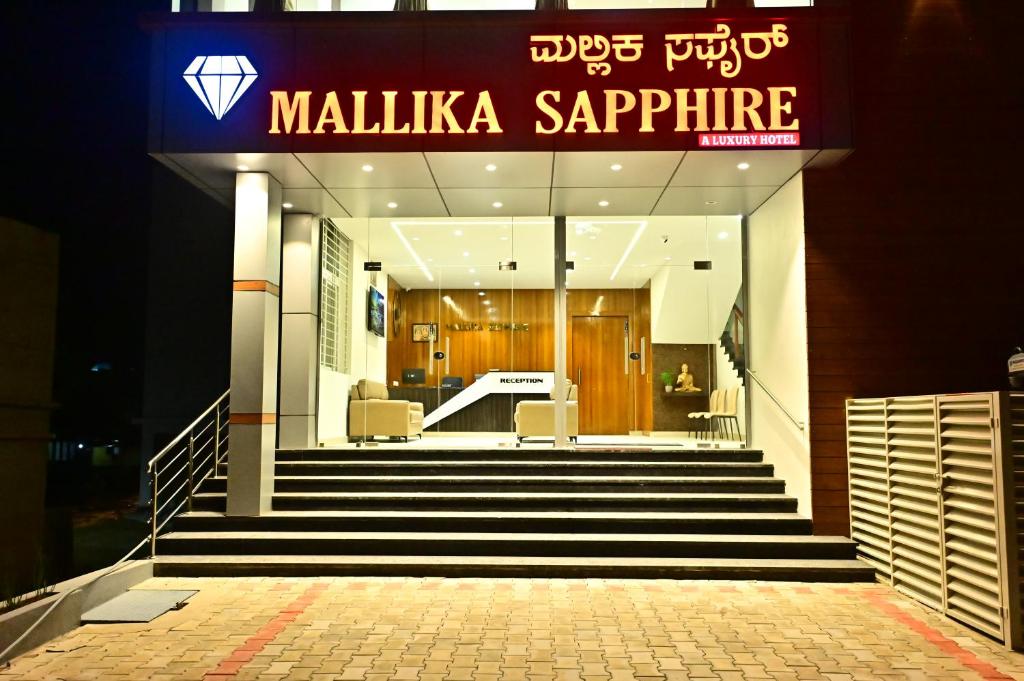 a lobby of a building with stairs and a sign at DOWNTOWN The Mallika Sapphire in Chikmagalūr
