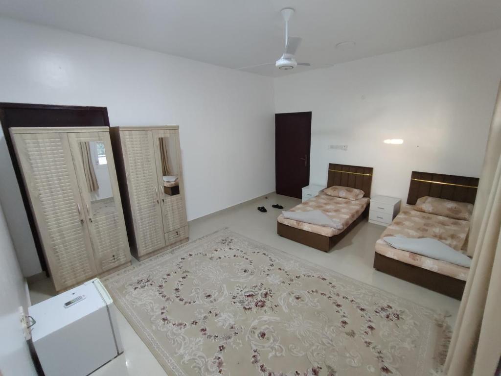 a large room with two beds and a rug at The best room for peace of mind in Muscat