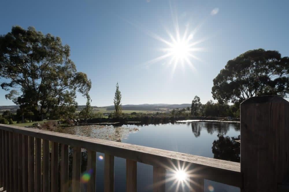 - une vue sur un étang avec le soleil dans le ciel dans l'établissement Rural Apartment with Stunning Views, à Relbia