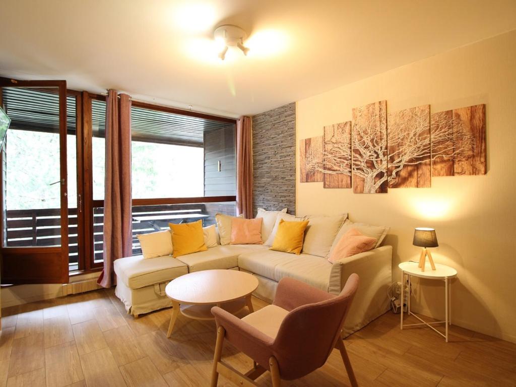 un salon avec un canapé et une table dans l'établissement Mont-Dore : Duplex T3 avec Parking, à 300m du centre - FR-1-608-268, à Le Mont-Dore