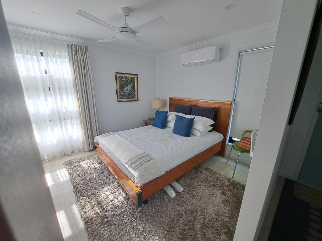 a bedroom with a bed with blue pillows at Pablos Retreat in Brisbane
