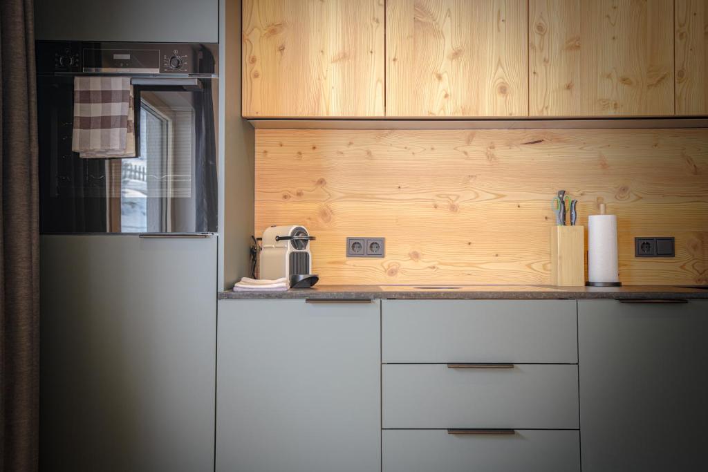 a kitchen with white cabinets and a white refrigerator at WOLF Apartments Padaun in Vals
