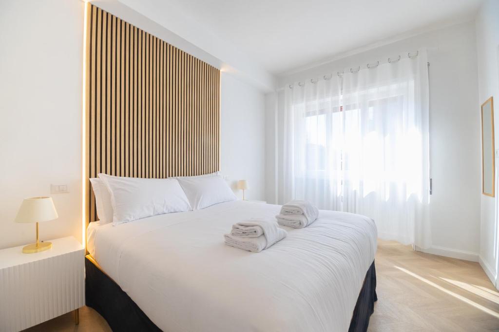 um quarto com uma grande cama branca com toalhas em Vatican City Apartment em Roma
