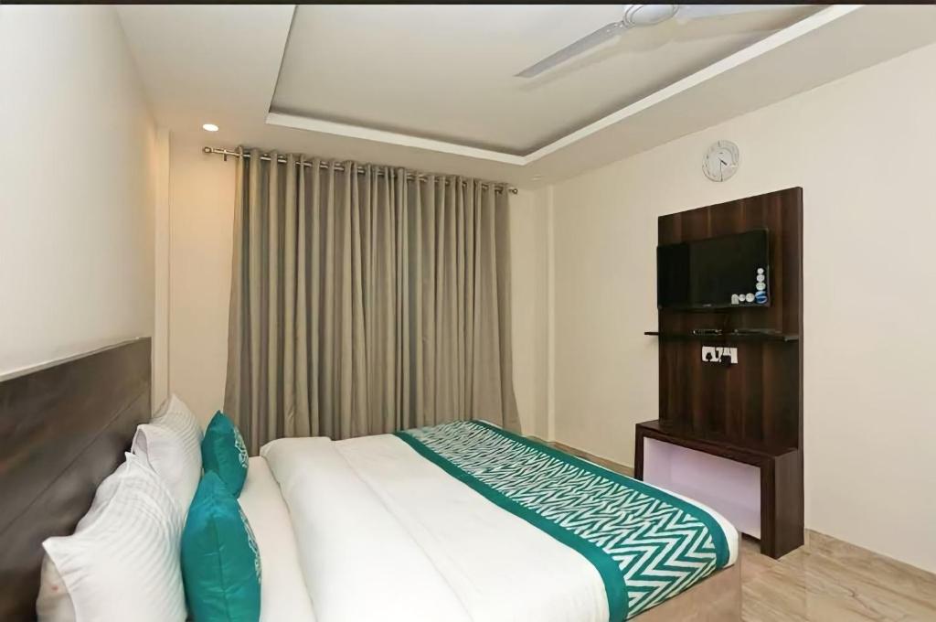 Hotel Global Stay Near Delhi Airport في نيودلهي: غرفه فندقيه سرير وتلفزيون