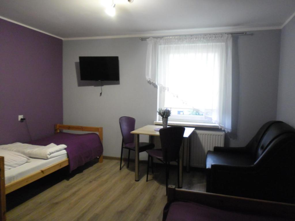 um quarto com uma cama, uma secretária e uma mesa em Pokoje Gościnne LaMa Gołuchów em Gołuchów