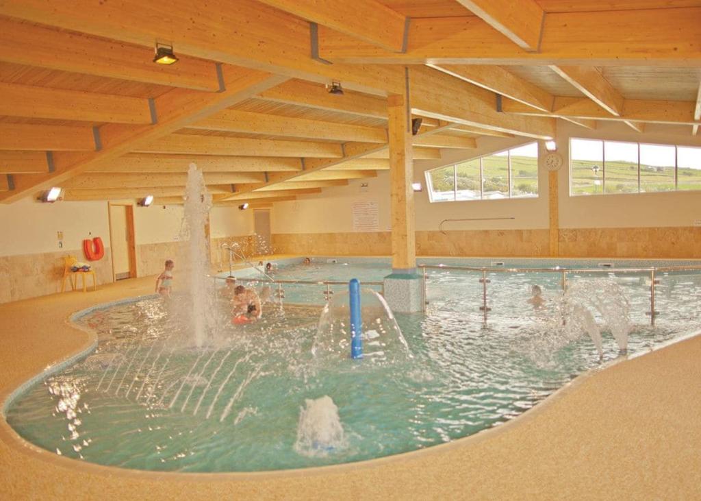 a swimming pool with a fountain in the middle at Sunbeach Holiday Park in Llwyngwril