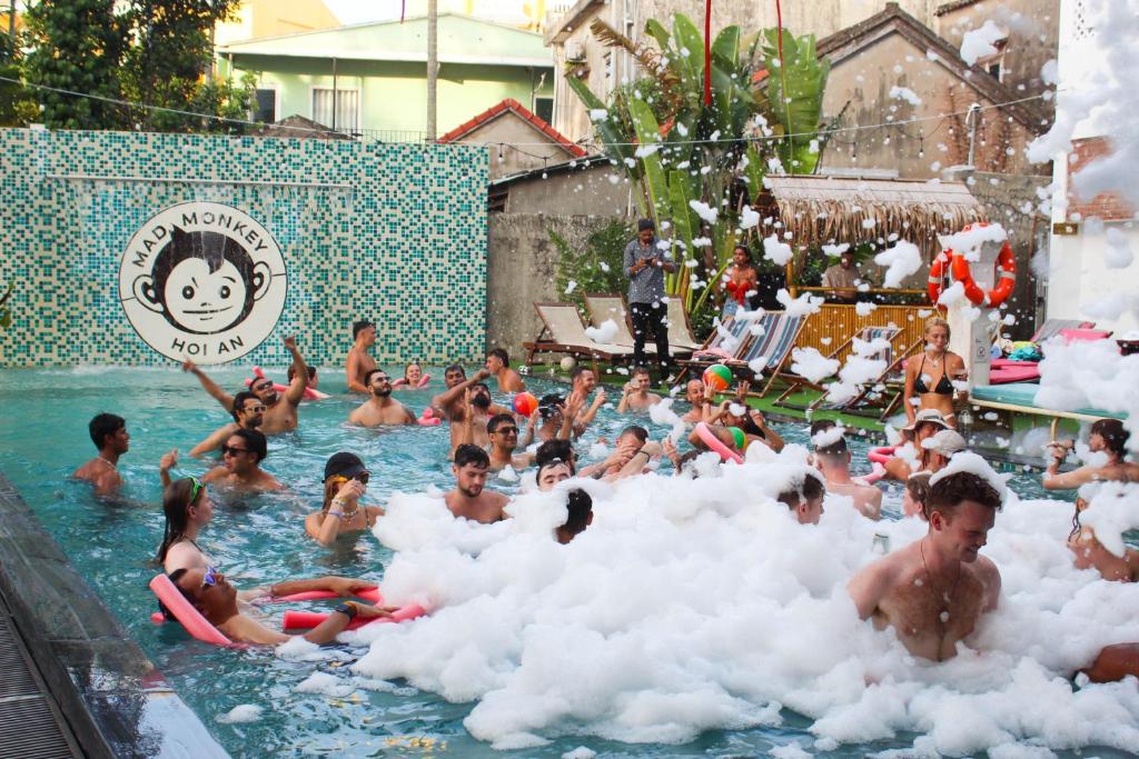 um grupo de pessoas em nuvens de algodão em uma piscina em Mad Monkey Hoi An em Hoi An