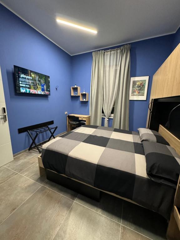 um quarto azul com uma cama e uma televisão em B&B Parma Centro em Parma