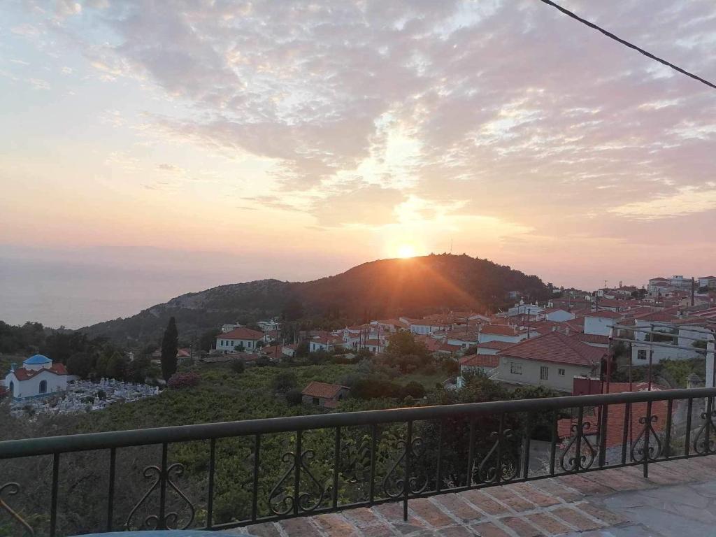 einen Blick auf den Sonnenuntergang vom Balkon einer Stadt in der Unterkunft Grammatikis house in Vourliótai