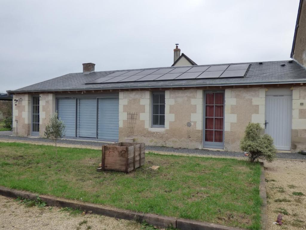 une maison avec des panneaux solaires en haut dans l'établissement Le Petit Pré, Gîte chez l'habitant, à Gizeux