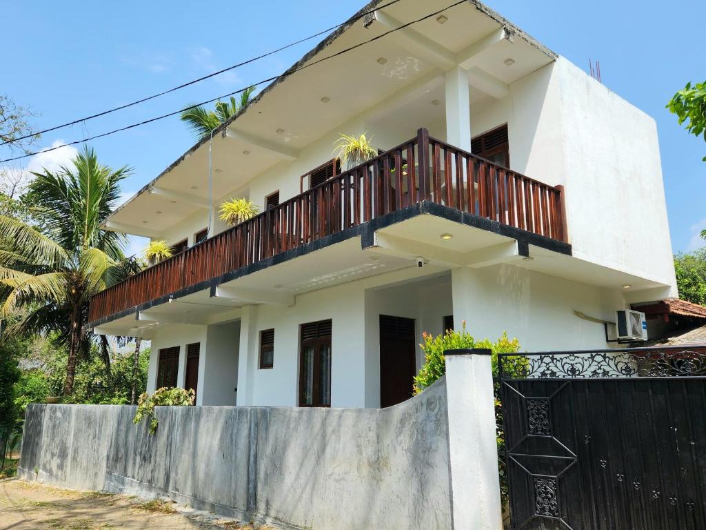 a house with a balcony on top of it at Sea Bay Inn Tangalle in Tangalle
