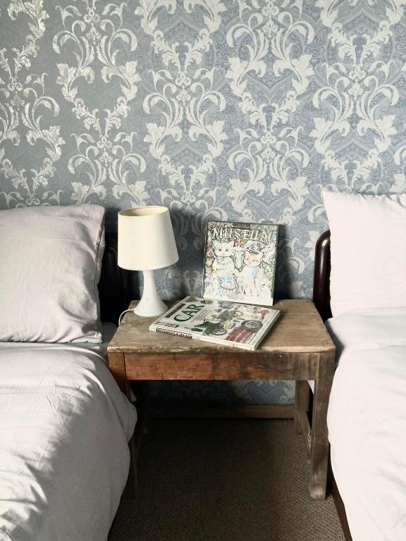 a room with two beds and a table with a lamp at Maison Petit Lapin メゾンプチラパン in Karuizawa