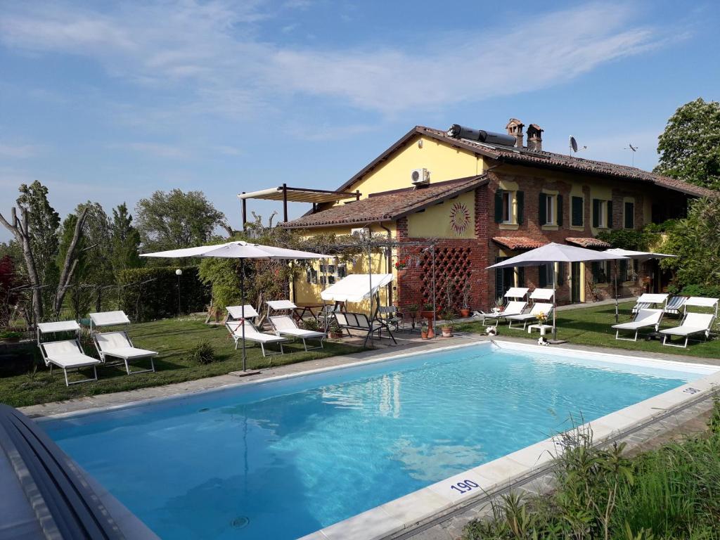 a villa with a swimming pool in front of a house at Relais Cascina San Martino in San Marzano Oliveto
