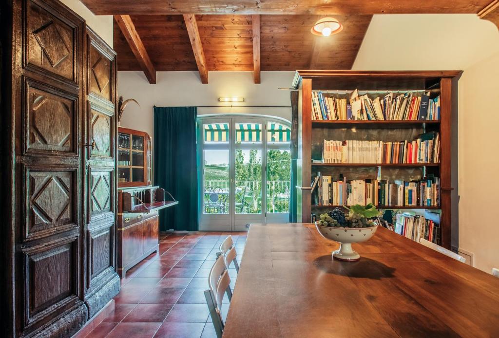 une salle à manger avec une grande table en bois et des étagères dans l'établissement Relais Cascina San Martino, à San Marzano Oliveto
