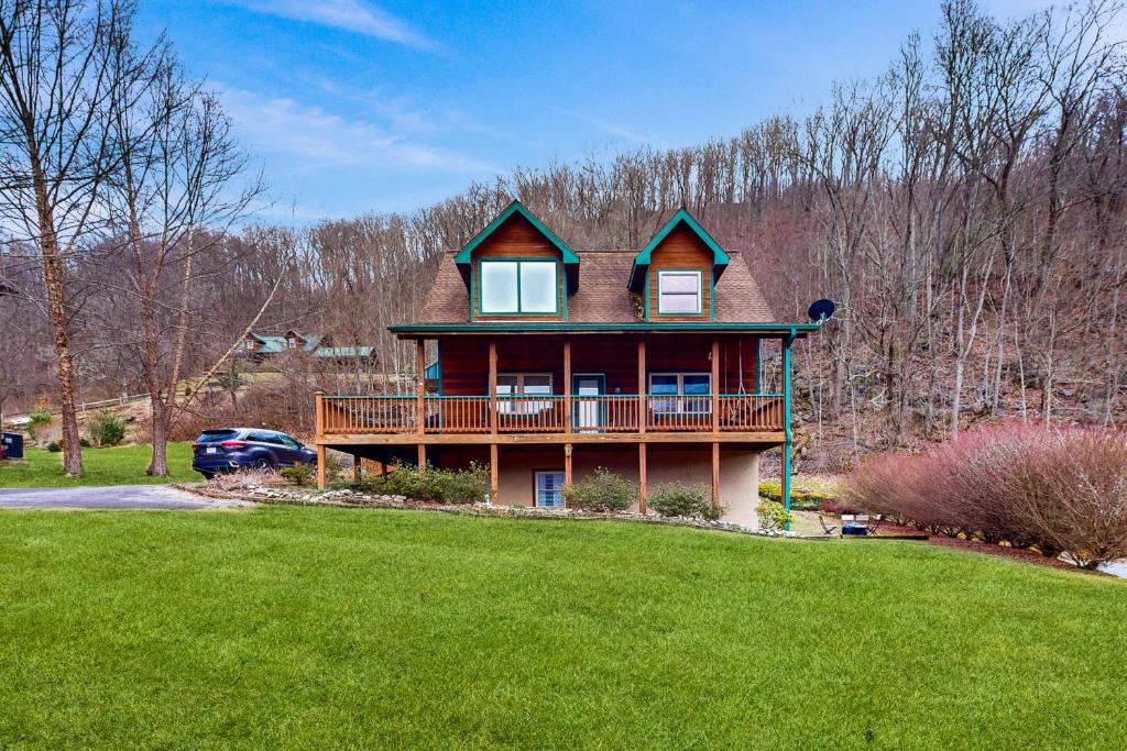 a large house with a deck on a green lawn at Up on Tanner Trail in Waynesville