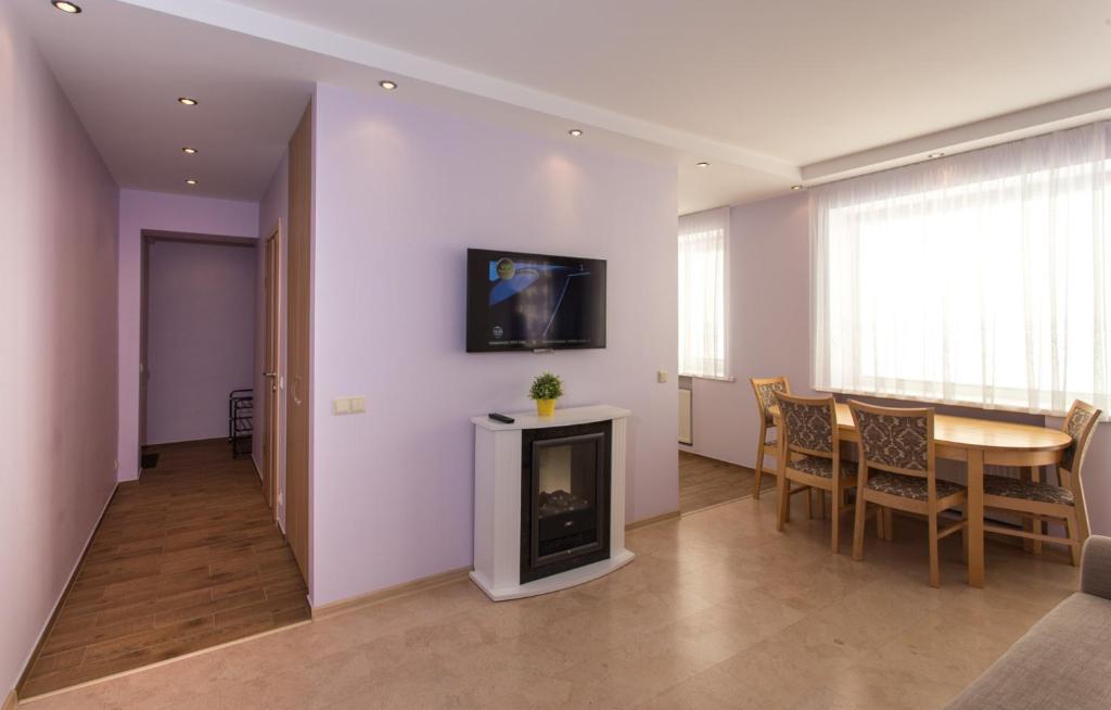 een woonkamer met een tafel en een open haard bij LeConte in Druskininkai