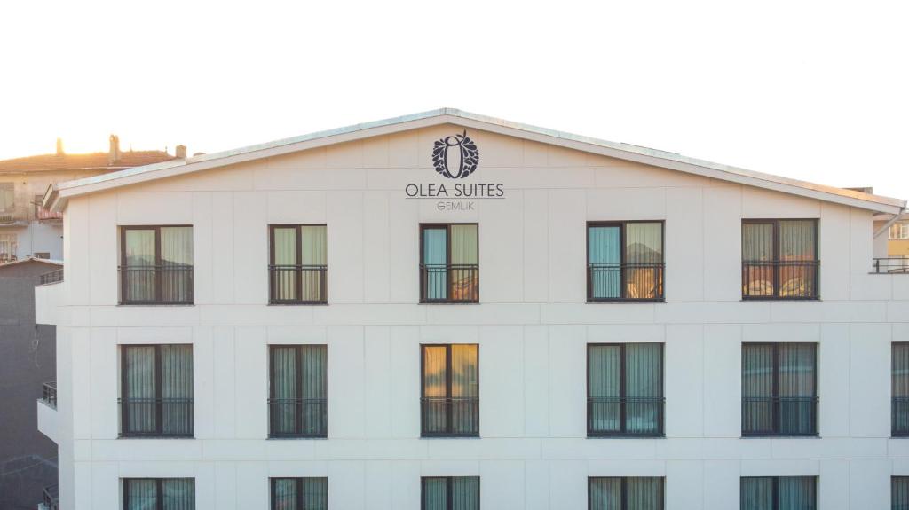 un edificio blanco con un reloj encima en Olea Suites Gemlik en Gemlik