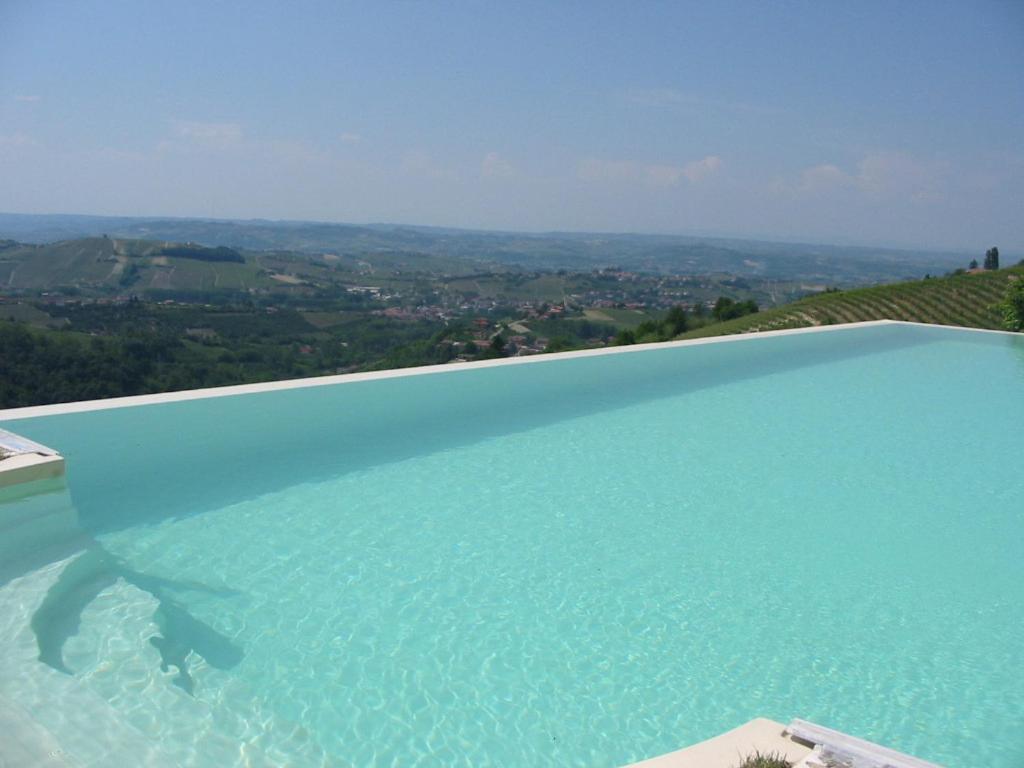 uma grande piscina azul com vista em Agriturismo Brusalino em Mango