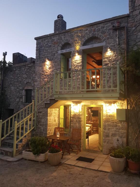 a stone house with a balcony and a table at Likno in Avgonyma