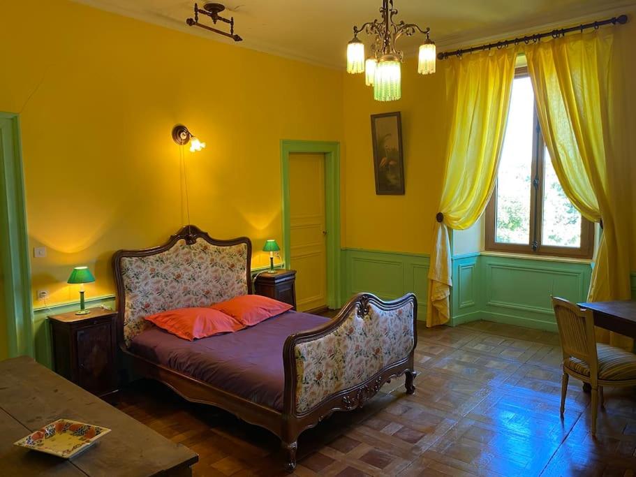 - une chambre avec un lit dans une pièce aux murs jaunes dans l'établissement Domaine de Linars ☆ L'Étage du Château ☆, à Le Truel