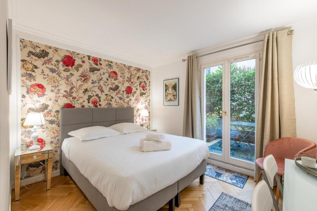 ein Schlafzimmer mit einem großen Bett und einem Fenster in der Unterkunft Geranimus Versailles Charost in Versailles
