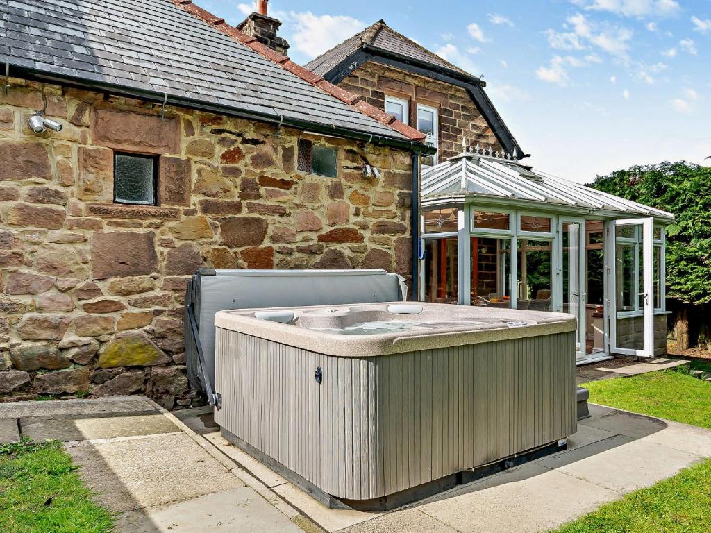 a hot tub sitting outside of a stone house at 4 bed in Cromford 52094 in Highpeak Junction