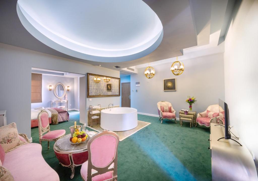 a large room with pink chairs and a table at Phoenicia Comfort Hotel in Bucharest