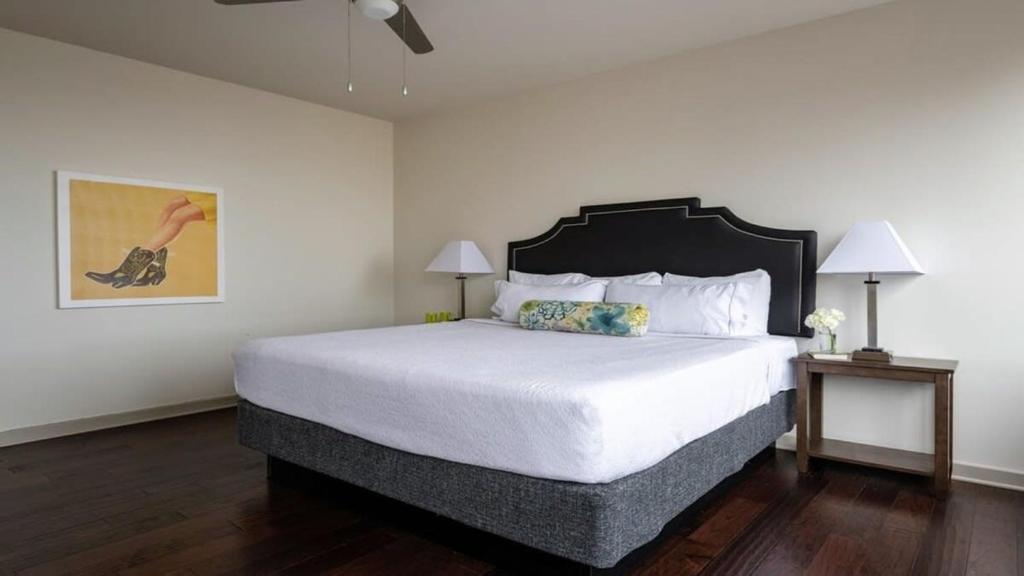 a bedroom with a large bed with white sheets at 18th FL Stylish CozySuites with roof pool, gym #2 in Dallas
