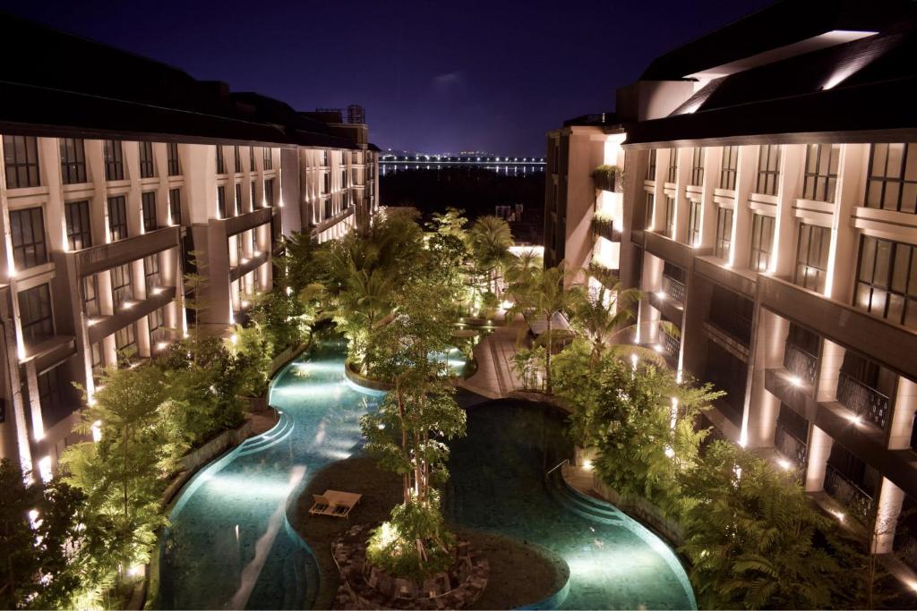 - une vue sur la piscine située entre deux bâtiments la nuit dans l'établissement Anagata Tanjung Benoa Bali, à Nusa Dua