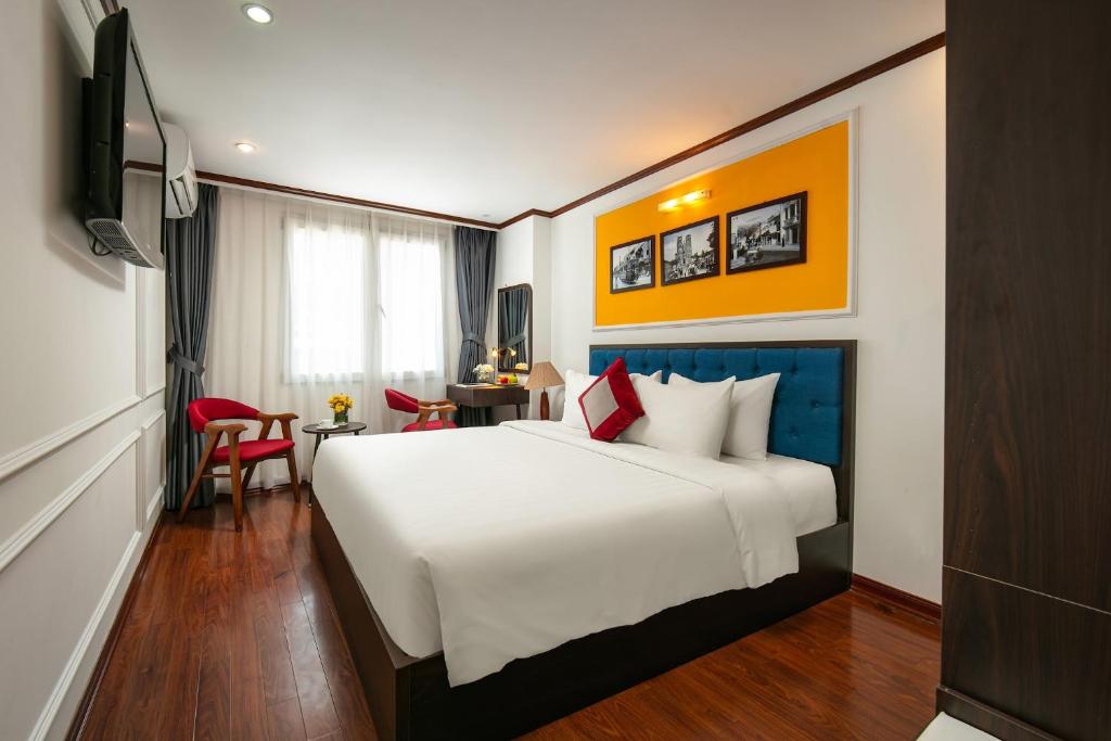 a hotel room with a large bed and a television at Silk Flower Hotel & Spa in Hanoi