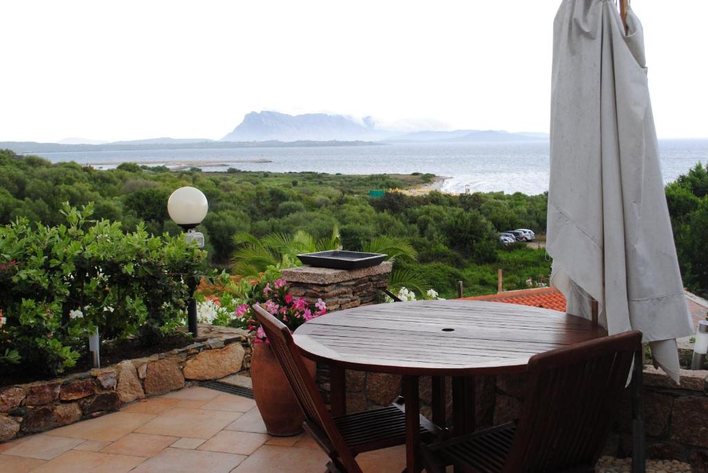 a table and chairs on a balcony with the ocean at Villa Minda in San Teodoro